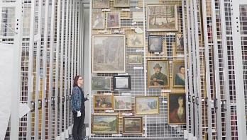 Digitale Depottour 2022 Foto aus dem Außendepot des Museums. Eine Person zieht ein Schubregister auf, an dem viele Gemälde hängen. © Stadt Göttingen