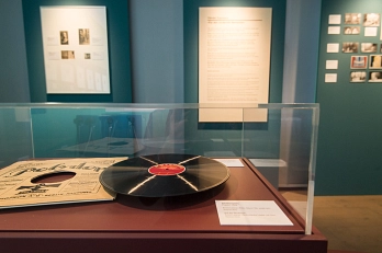 Foto aus der Sonderausstellung: Händel_Göttingen_1920. Im Vordergrund steht eine Vitrine, in der sich ein Plattenspieler befindet. Im Hintergrund hängen Text und Bilder an der Wand.&nbsp;&copy;&nbsp;Stadt Göttingen