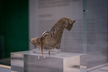 Ein kleines Spielzeugpferd aus Faststeinzeug. Die Beine des Pferdes und der Reiter fehlen. Das Pferd steht auf einem Plexiglassockel in einer Vitrine.&nbsp;&copy;&nbsp;Katrin Raabe